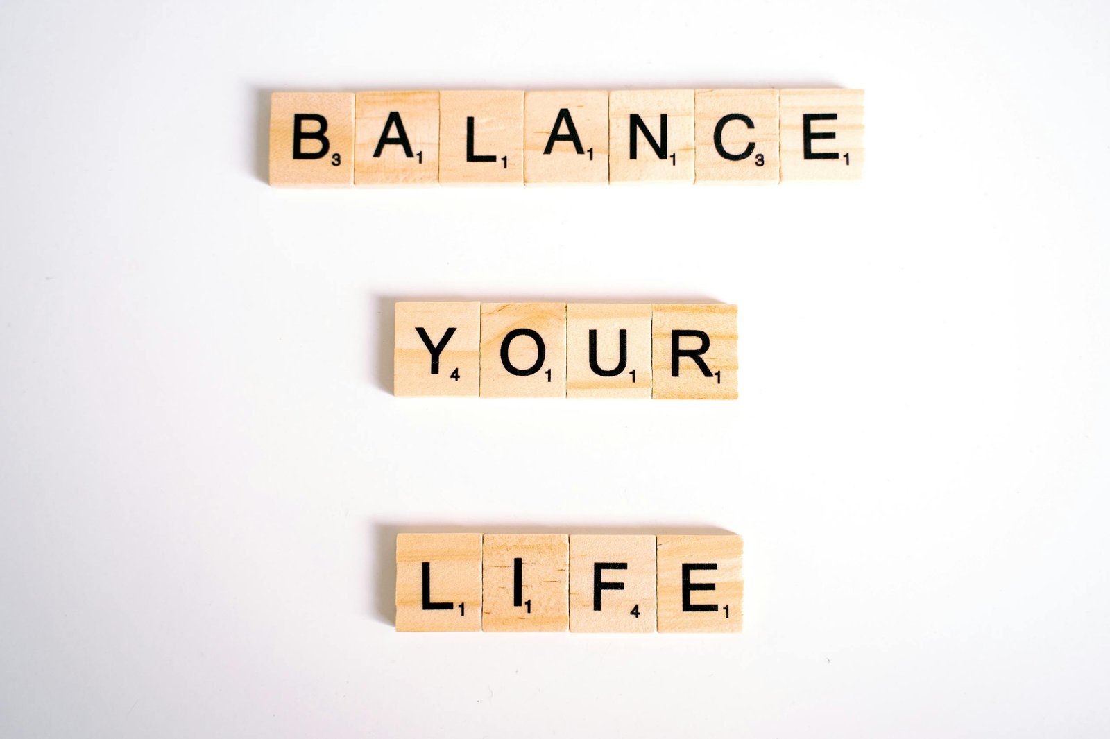 Inspirational message 'Balance Your Life' made with Scrabble tiles on a white background.